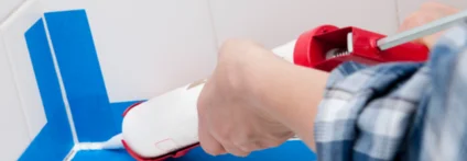 Person verwendet Dichtmittelpistole in Badezimmer